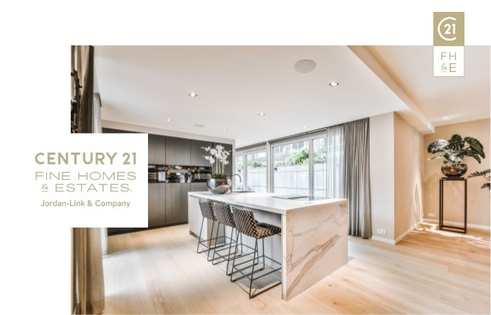 Elegant modern kitchen with a marble island, sleek cabinetry, and high-end appliances, labeled "CENTURY 21 Fine Homes & Estates, Jordan-Link & Company